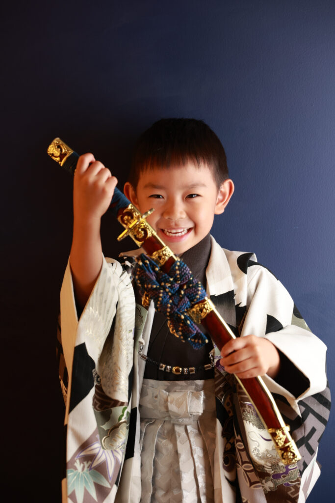 刀を持ったポーズをする男の子の写真