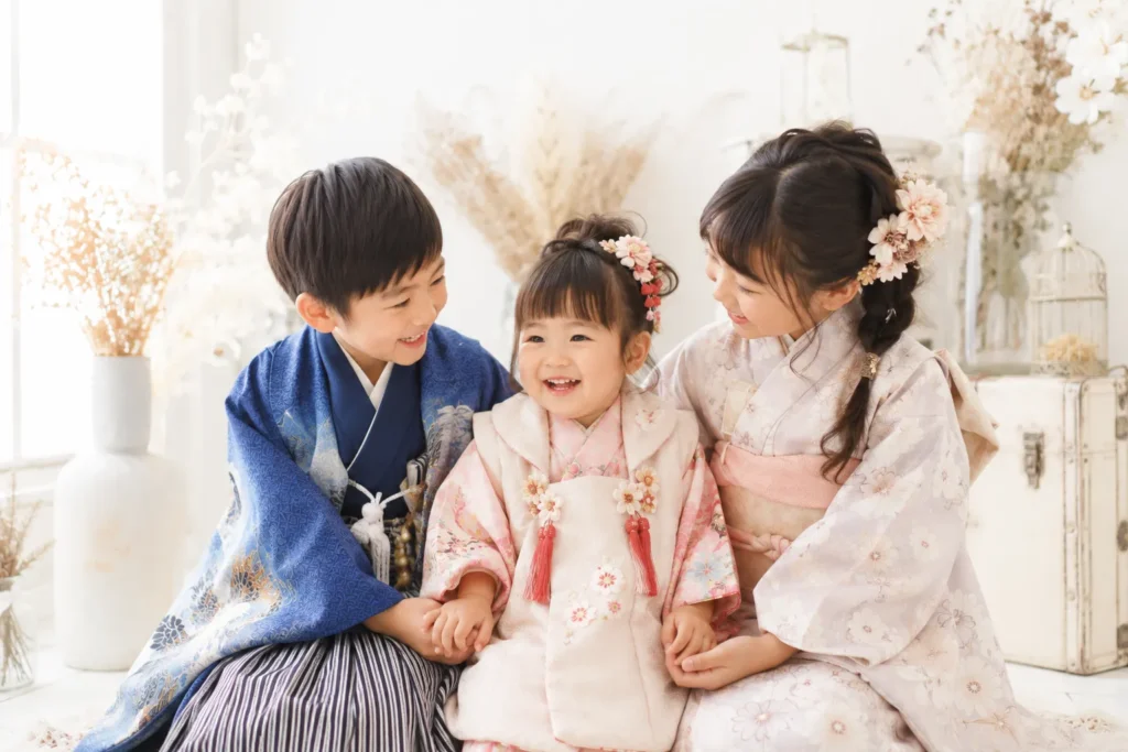 兄弟と一緒で安心した笑顔を見せる七五三3歳女の子のスタジオ写真