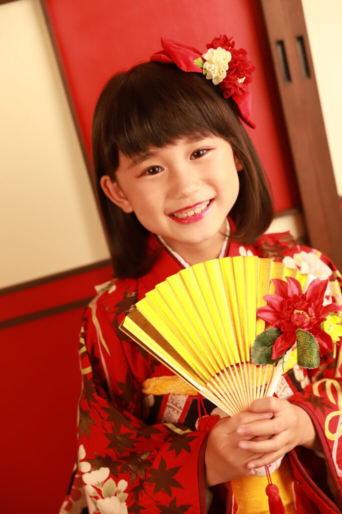 スタジオで着物姿をにっこり見せる7歳の女の子