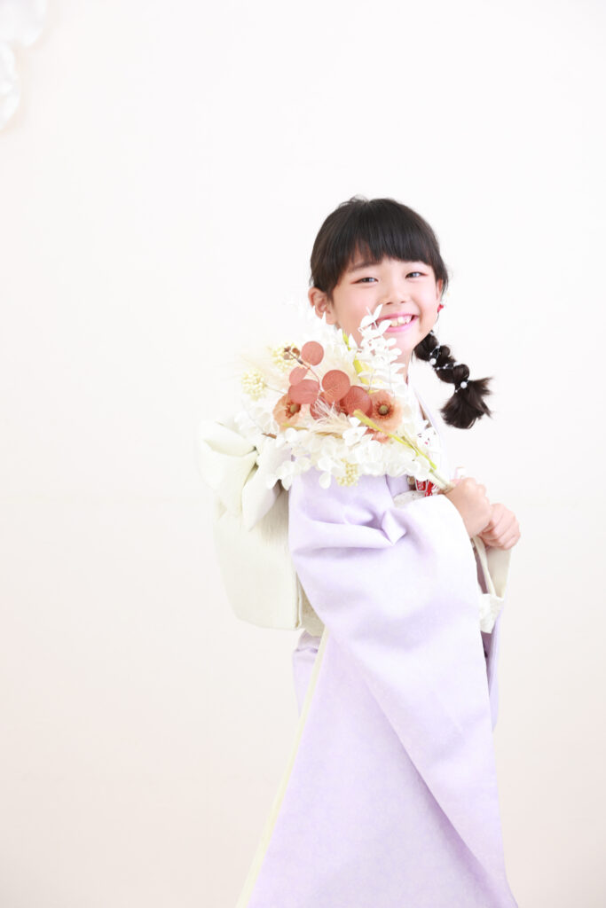 ラベンダーカラーの着物で大人っぽく立つ7歳の女の子