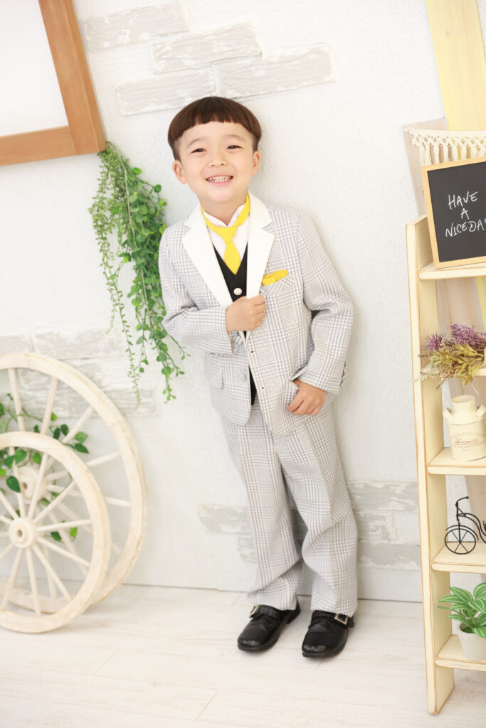 グレーのチェック柄スーツでポーズを決める5歳男の子