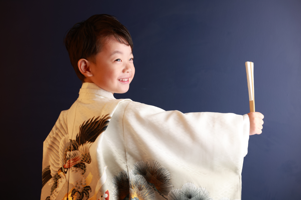 白い羽織姿で扇子を持つ後ろ姿の5歳男の子