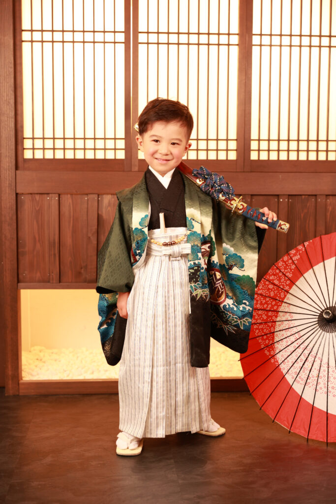 和風の背景で刀を肩にかけた5歳男の子の立ち姿