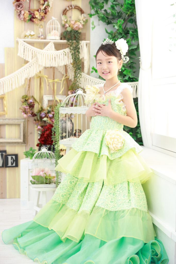 グリーンのドレスで微笑む7歳の女の子