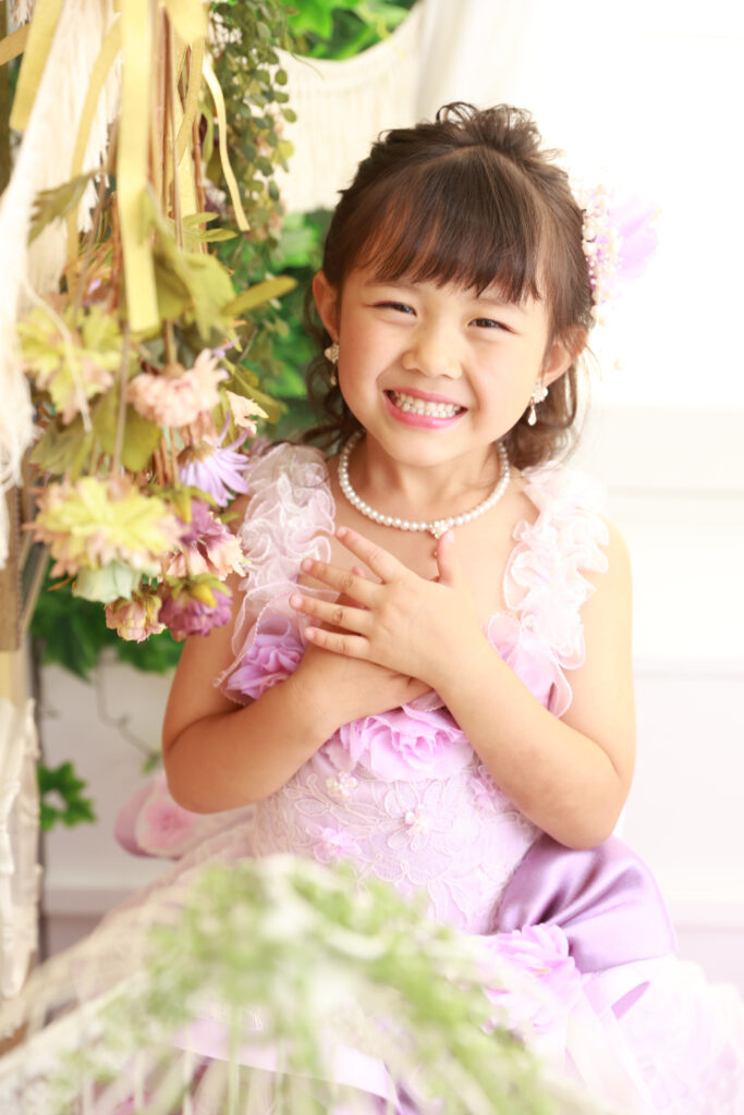 ドライフラワーに囲まれてドレスを着た7歳の女の子