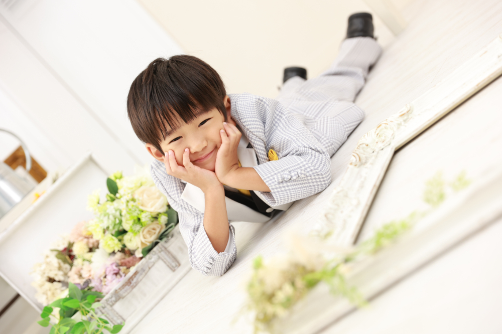 スーツ姿で横になってポーズを決める5歳の男の子