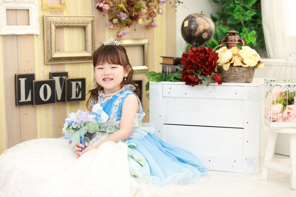 アンティーク背景でブルーのドレスを着た3歳の女の子