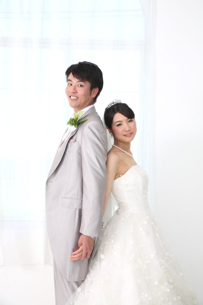 ウエディングドレス姿で手をつなぐ新郎新婦の写真