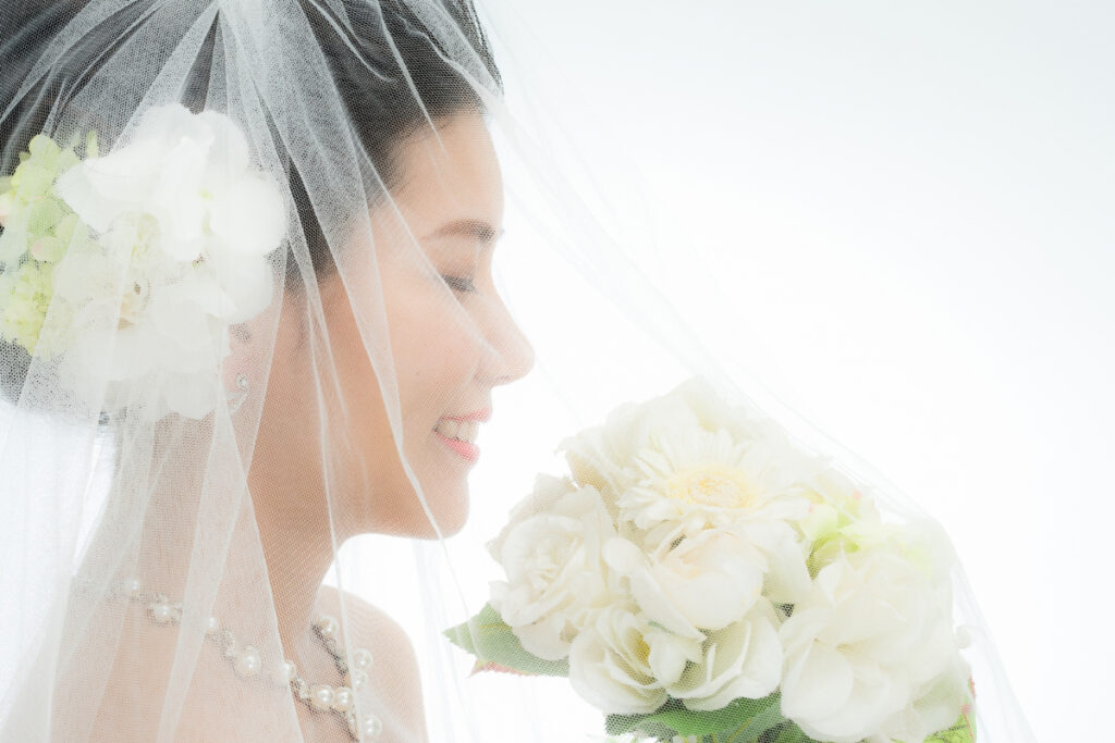 ウエディングドレス姿で笑顔を見せる新婦のスタジオ撮影シーン