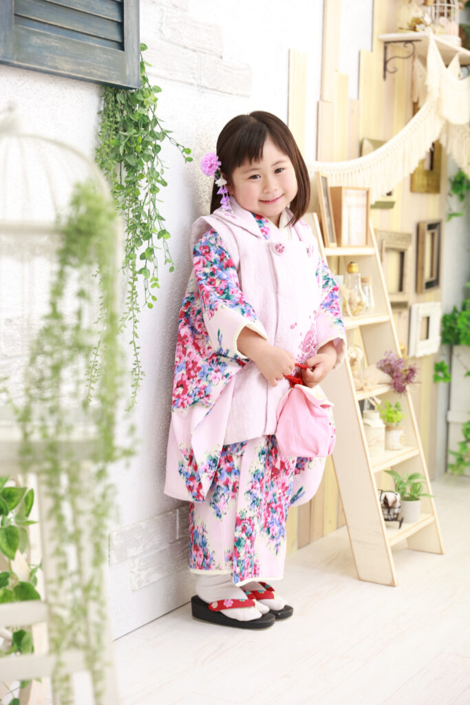 ピンクの花柄着物を着て笑顔を見せる3歳の女の子