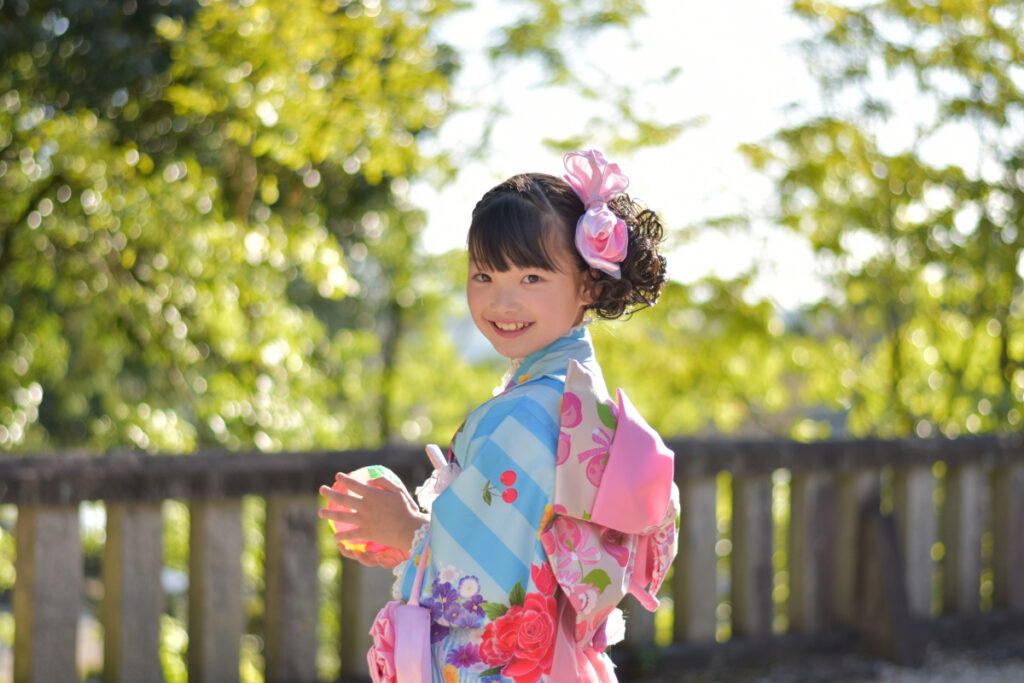 カメラを向けられて笑顔の七五三の女の子