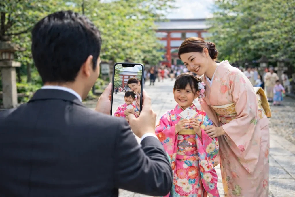 七五三のお参り前に神社で母と子どもの写真を撮る父親の様子