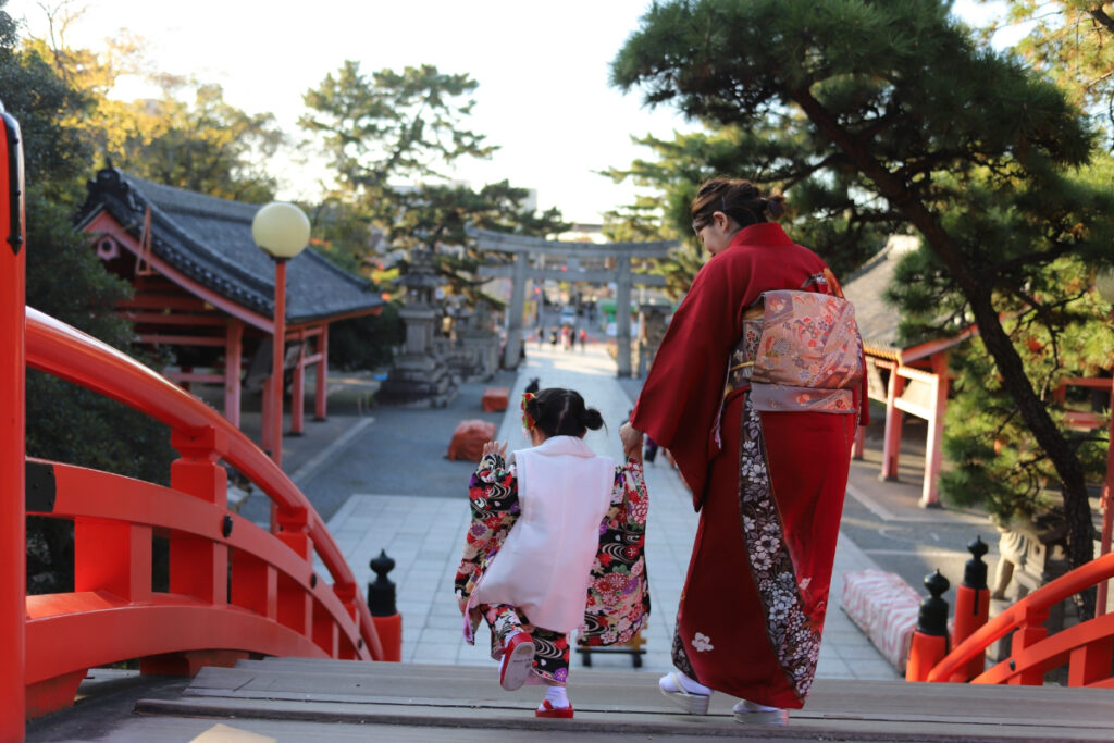 神社で参拝する七五三の親子