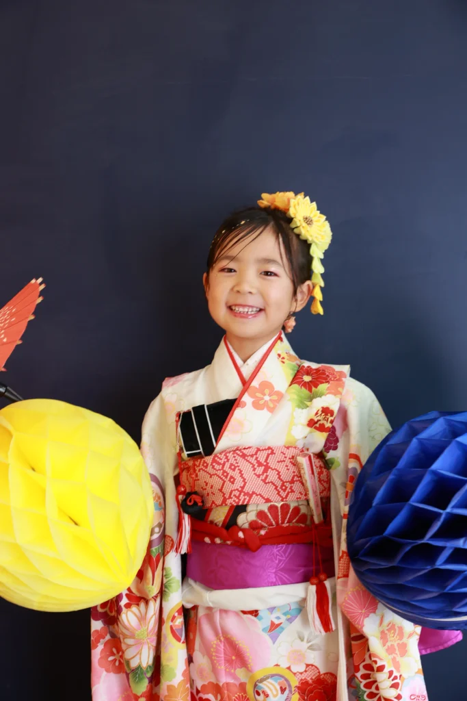明るい色の重ね衿と花飾りで春らしい華やかさが引き立つ七五三の女の子