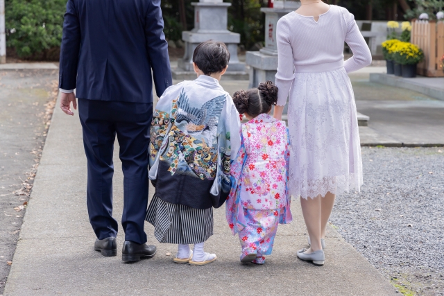 空いている神社でお参りする家族
