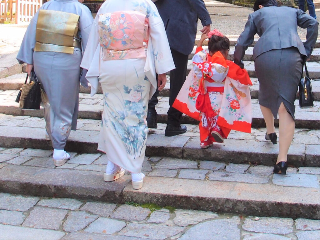 祖父母と三世代で七五三詣りする家族