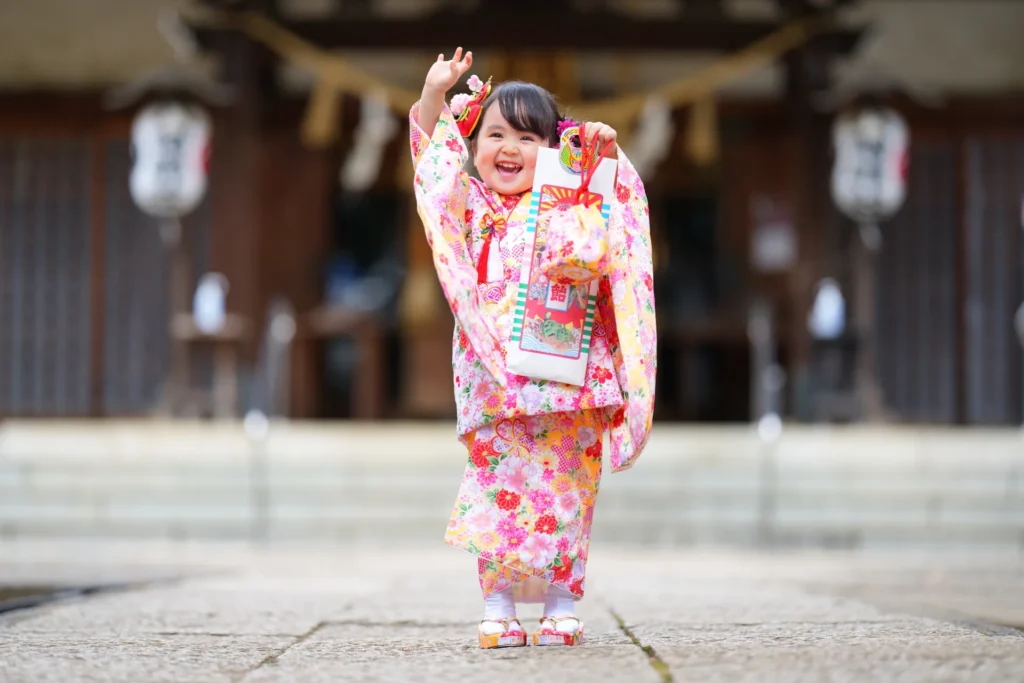 千歳飴を手に笑顔を見せる七五三の女の子