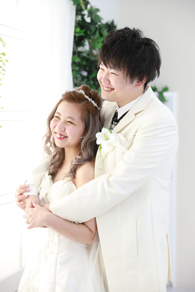 手を取り合って笑う新郎新婦のナチュラルカット