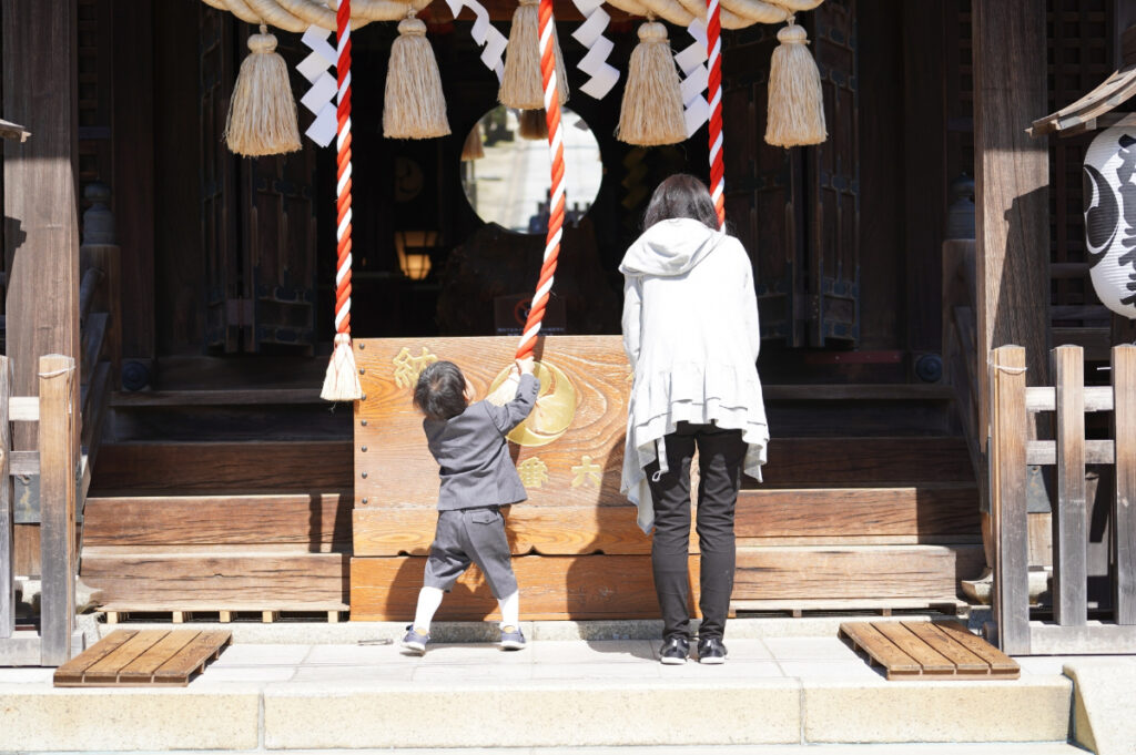 神社にお参りする親子