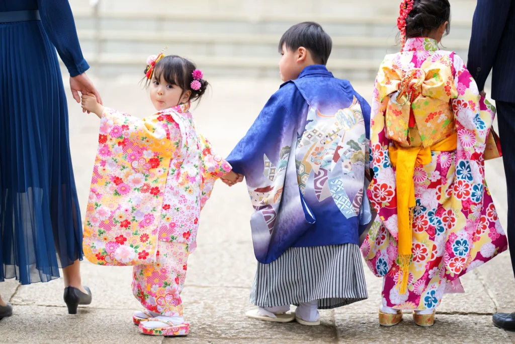 神社の参道で七五三のお参りを楽しむ家族の写真