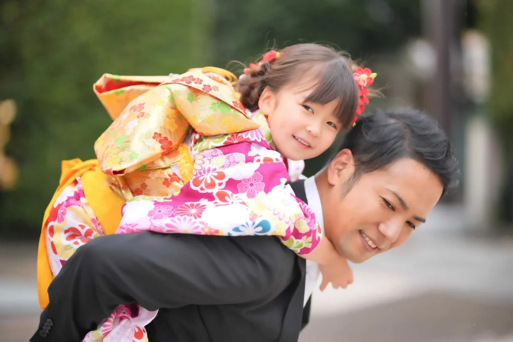 七五三の娘をおんぶする父