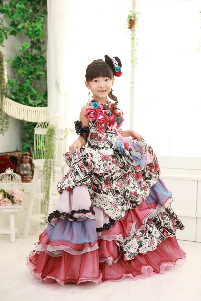 ７歳の女の子が黒と赤の個性的なドレスを着ている