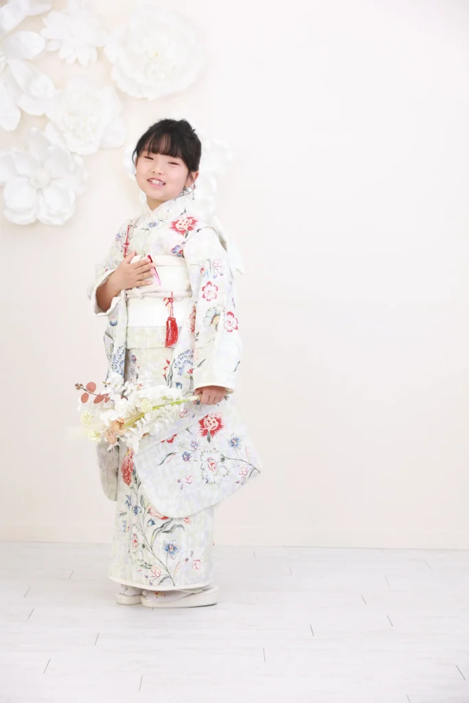 ７歳の女の子がアイボリー系のやさしい色合いの着物を着ている