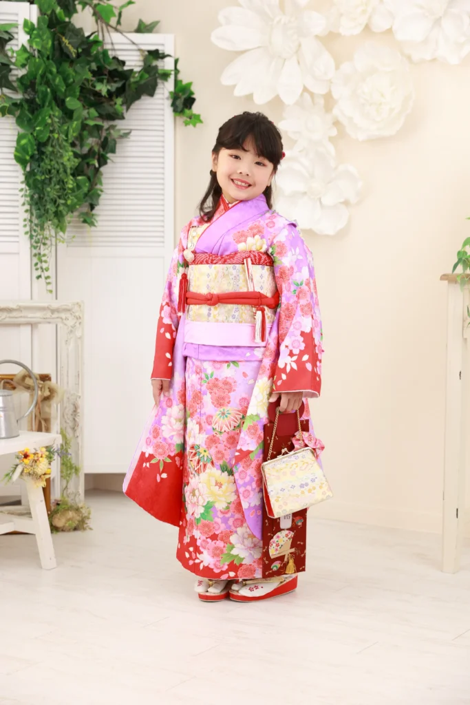 ７歳の女の子が紫ピンクと赤の華やかな七五三着物を着ている